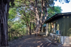 Outdoor view of cabins at sunset on cliff ledge.