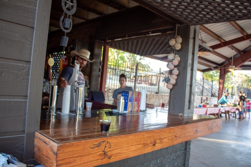 Rancher serving a drink for a patron at the outdoor bar.